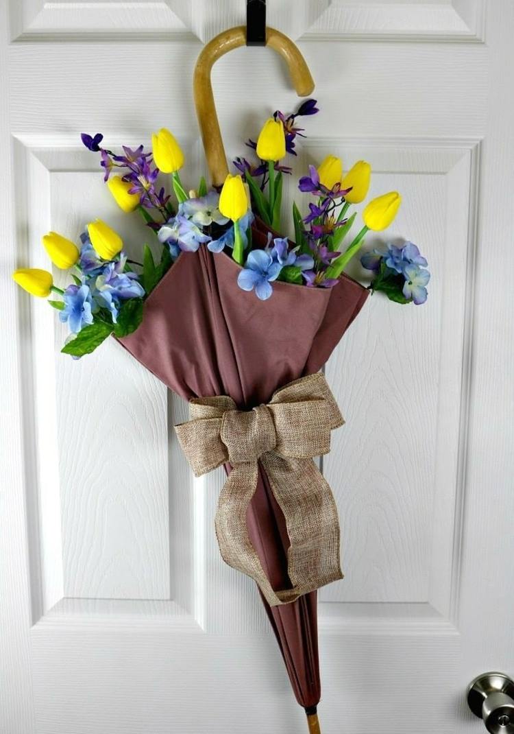 Broken umbrella as a decoration for the entrance door with tulips