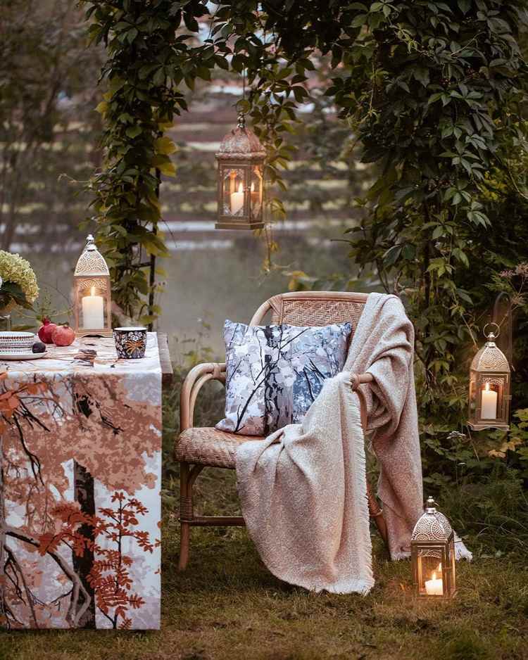 Metal candle holders and warm fabrics bring an autumn atmosphere to the terrace