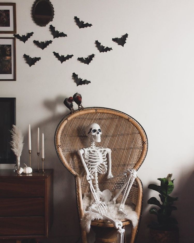 Skelett sitzt in einem Pfauensessel - Boho Halloween