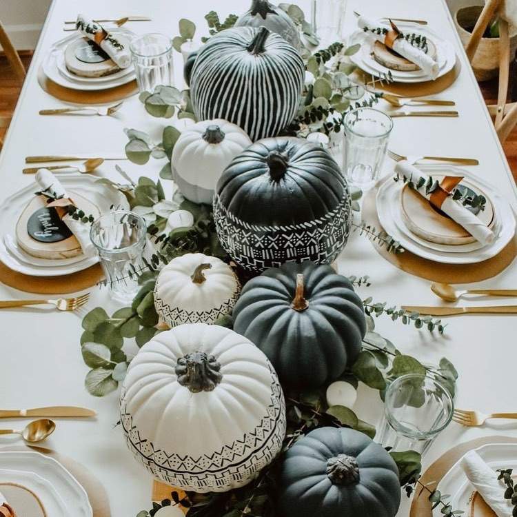 Tischdeko zu Boho Halloween mit schwarzen und weißen Kürbissen