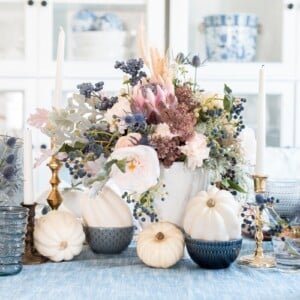 Vintage Herbstdeko Tisch mit weißen Kürbissen und blauen und rosa trockenen und frischen Blumen