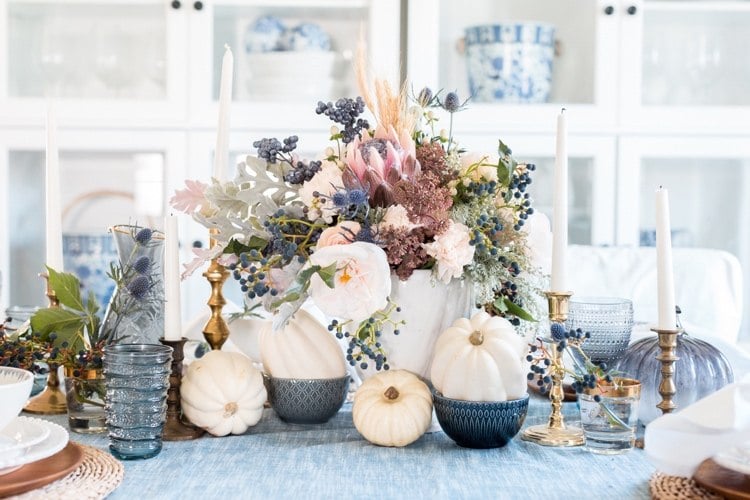 Vintage Herbstdeko Tisch mit weißen Kürbissen und blauen und rosa trockenen und frischen Blumen