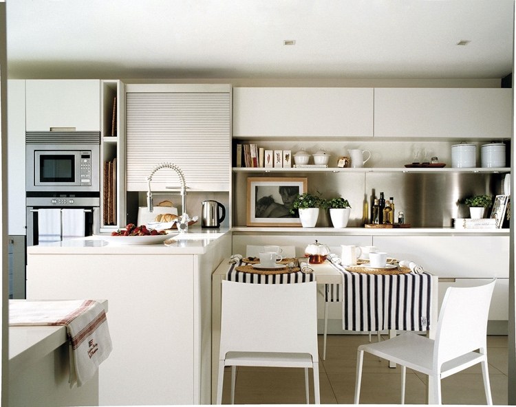 White U-shaped kitchen with peninsula and dining table
