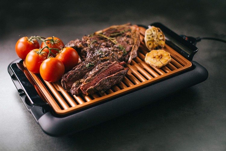 elektrischer grill mit steak und rispentomaten darauf als variante für rauchfreies grillen zu hause
