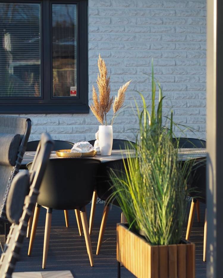dried grasses in a vase on the outdoor dining table