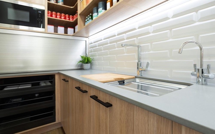 small kitchen with strappy back wall, gray worktop and wooden base units