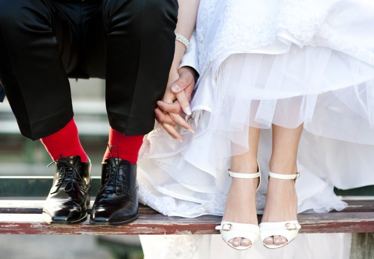 bright red socks as an accent in the wedding outfit for groom with bride in white dress