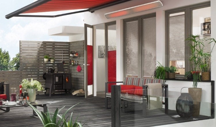mit markise überdachte terrasse in grauen und roten farbtönen verfügt auch über elektrischen heizstrahler