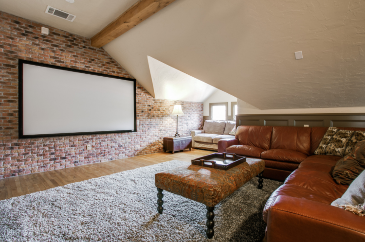 praktische raumnutzung im dachgeschoss mit ziegelwand und heimkino sofa