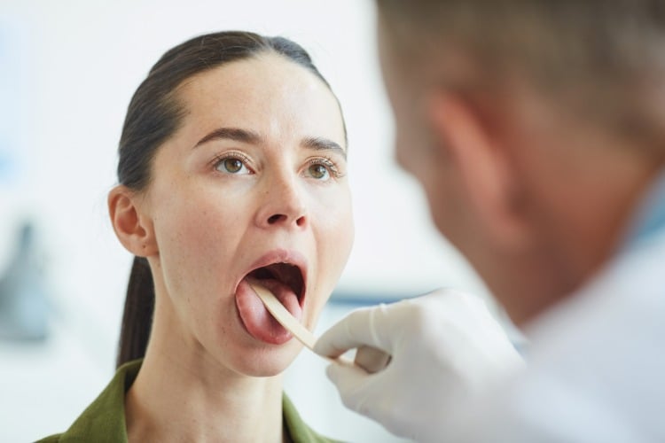 weibliche patientin beim arzt zur untersuchung der mundhöhle
