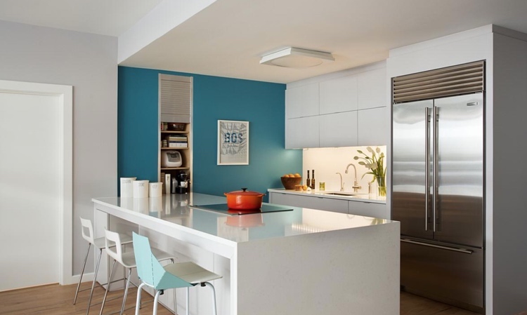 white kitchen with island and turquoise wall