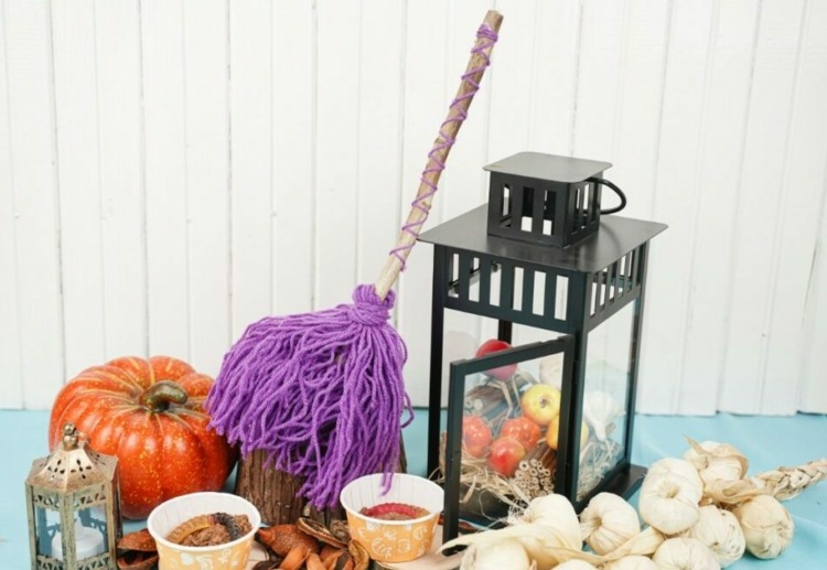 Idee für einen lila Besen aus Wolle - Tisch zu Halloween dekorieren mit Laterne und Kürbis