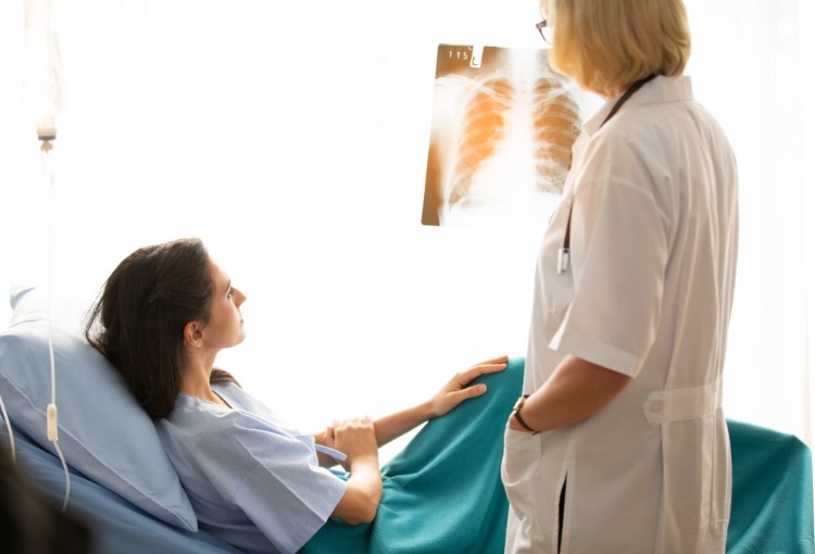 ärztin zeigt patientin im krankenhaus röntgenaufnahme von lunge wegen covid 19 infektion