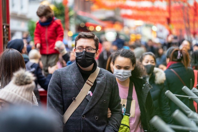 menschen auf der straße tragen schutzmasken während covid 19 pandemie in london