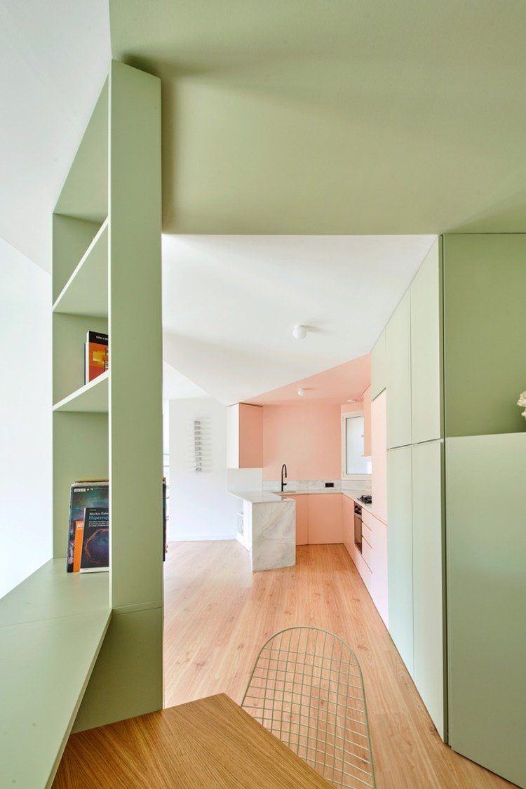 offene einbauküche neben kleinem arbeitszimmer mit minzgrünen regalen