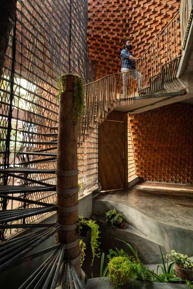 ungewöhnliches treppenhaus aus wiederverwendeten materialien wie bambus und metallgittern in modernem haus