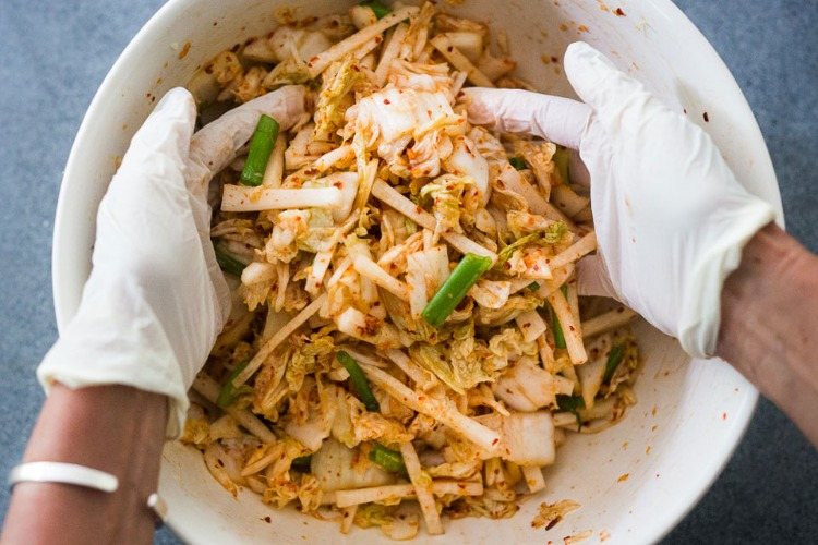 zubereitung von kimchi mit handschuhen für bessere hygiene