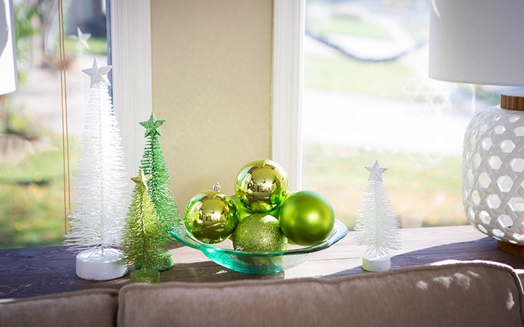 Couchtisch weihnachtlich dekorieren mit Schale mit grünen Christbaumkugeln und künstlichen Weihnachtsbäume