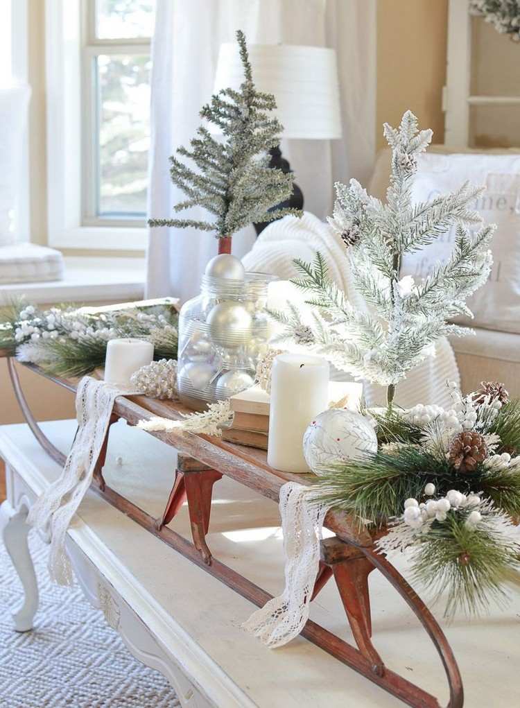 Couchtisch weihnachtlich dekorieren mit Schlitten und LED-Kerzen und Tannenzweigen