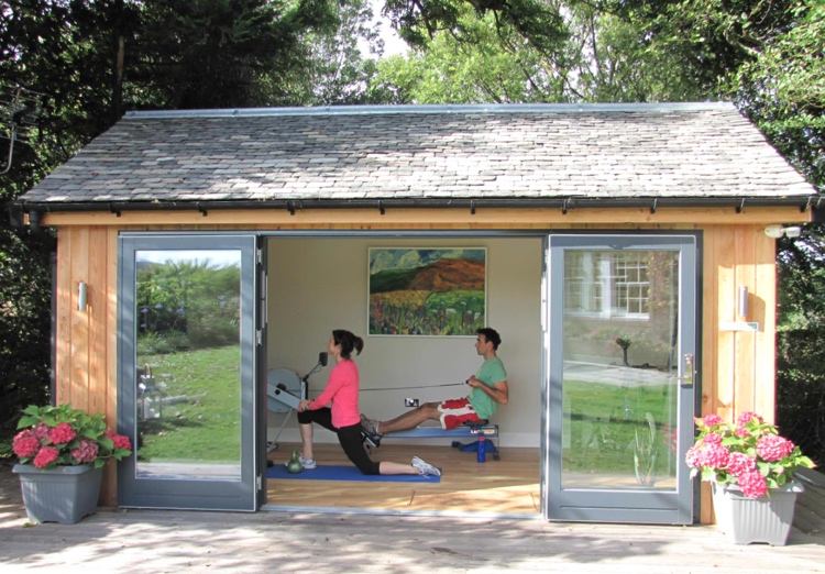 Fitness im Gartenhaus mit Rudergerät und Yogamatte