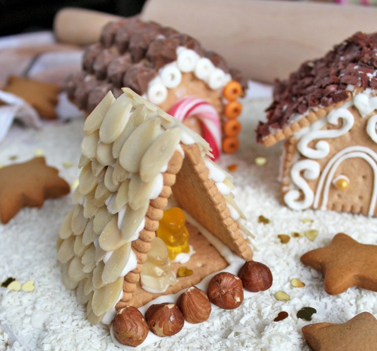 Lebkuchenhaus aus Butterkeksen in dreieckiger Form und mit Nüssen dekoriert