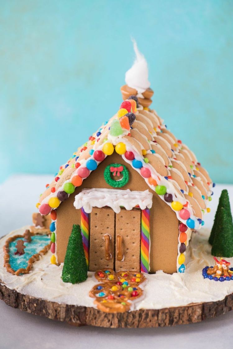 Lebkuchenhaus dekorieren mit kleinen Keksen für die Dachziegel und Tür