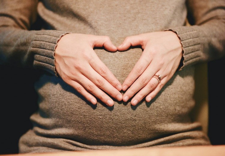 Schwangere Frau im Winter Hände am Babybauch