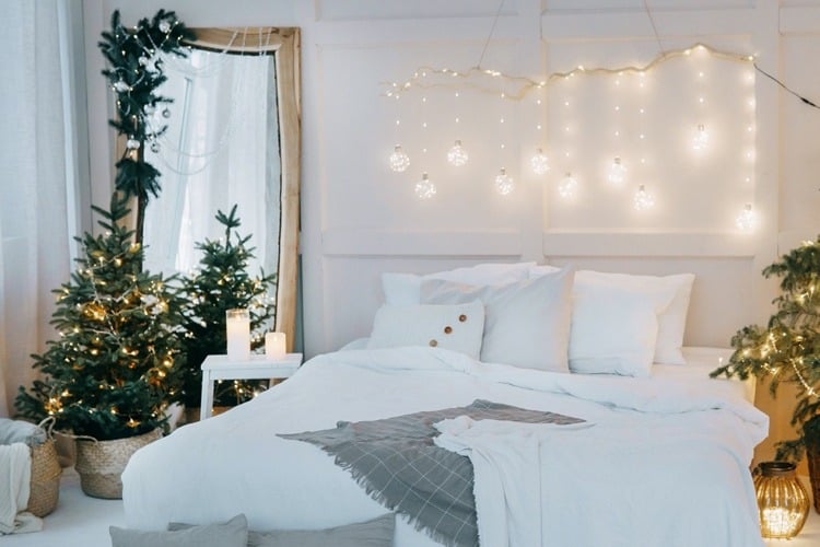 Spiegel im Schlafzimmer mit grünen Zweigen, Lichter- und Perlenketten dekoriert
