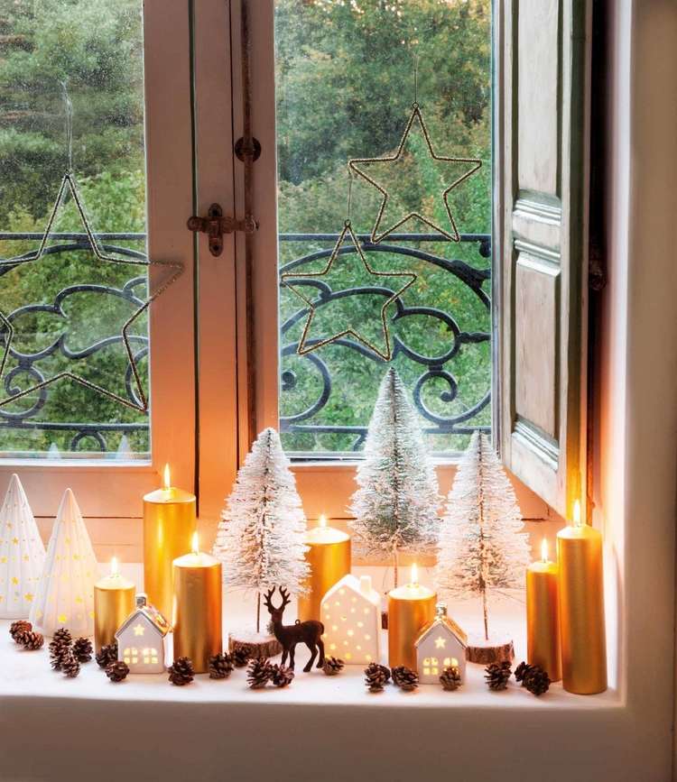 Winterdeko für die Fensterbank mit goldenen Stumpenkerzen Zapfen und Baumfiguren