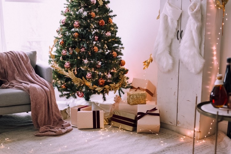 Wohnzimmer festlich schmücken Dekoideen mit Lichterketten und Tannenbaum mit Goldgirlande