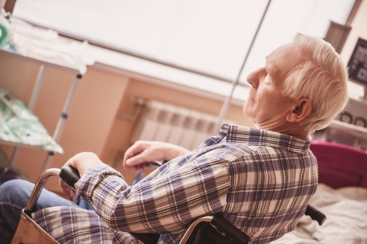alter mann sitzt im rollstuhl als patient im krankenhaus