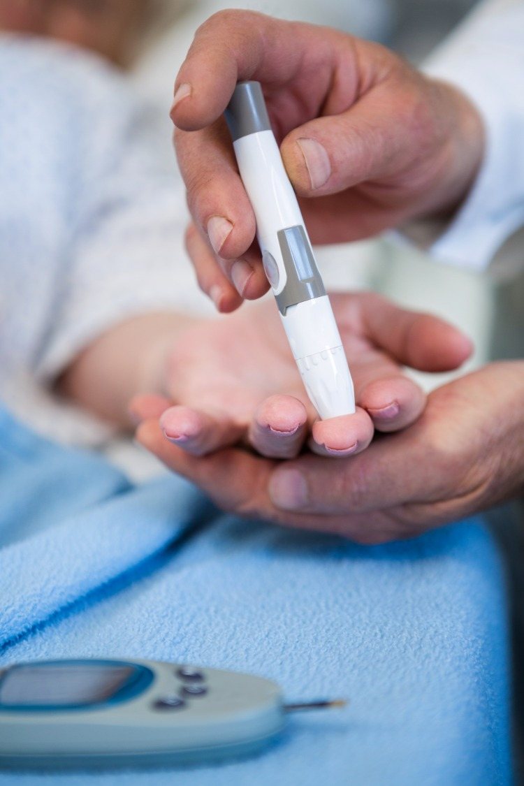 arzt testet insulin bei patient mit diabetes mellitus typ 2 anhand eines blutzuckermessgerätes