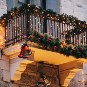 balkon weihnachtlich schmücken mit lichterketten glocken und tannengirlanden