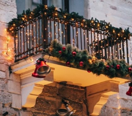 balkon weihnachtlich schmücken mit lichterketten glocken und tannengirlanden