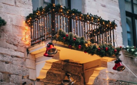 balkon weihnachtlich schmücken mit lichterketten glocken und tannengirlanden