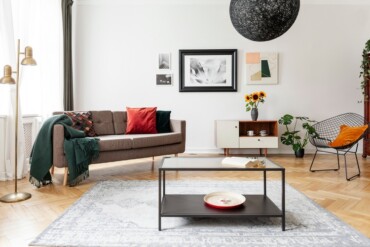 wohnzimmer in midcentury modern stil mit holzparkett und teppich in grau