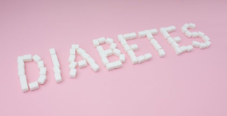 zuckerwürfel formen diabetes schrift auf rosafarbenem hintergrund