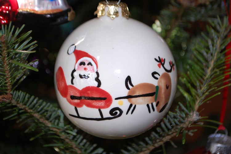 Nikolaus im Schlitten und Rentier mit Fingerabdrücken auf Weihnachtskugel bemalt