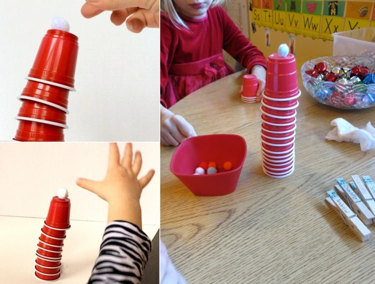 Turm bauen mit Kindern - Rote Becher und weiße Bommeln stapeln