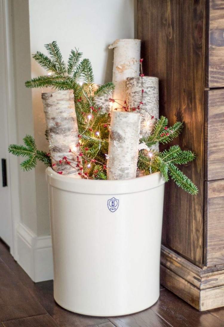 Weihnachtlich dekorieren im Landhausstil Holzscheite in Eimer mit Beeren Zweigen und Lichtern