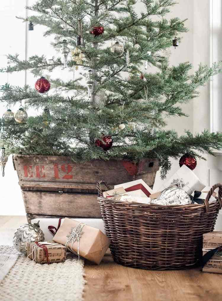 Weihnachtsbaum in Holzkiste arrangieren Geschenke in Korb füllen