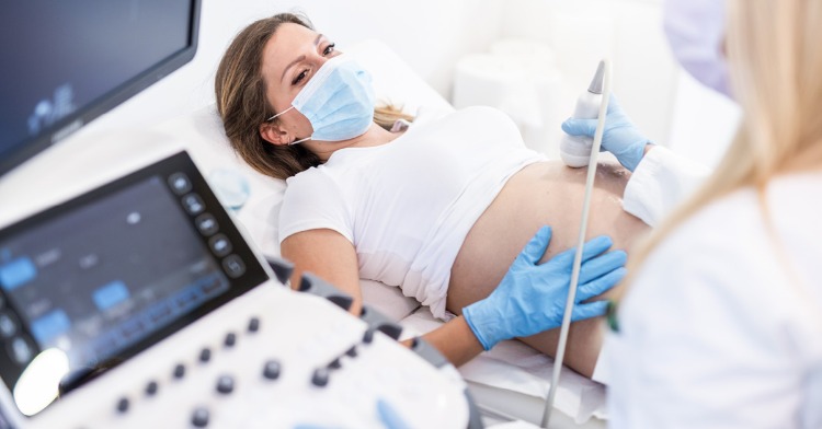 gynäkologe untersucht schwangere frauen mit covid 19 anhand von ultraschall beim krankenhausaufenthalt