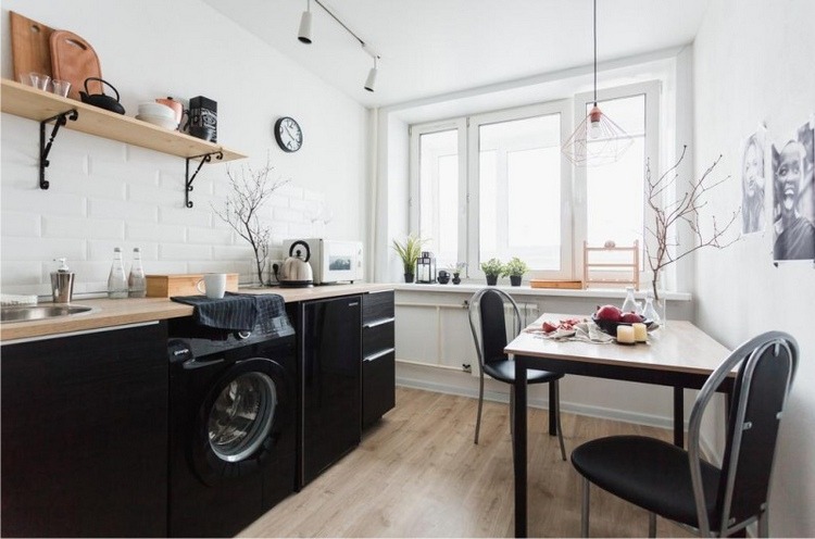 schwarze Küche und schwarze Waschmaschine mit Holz Arbeitsplatte