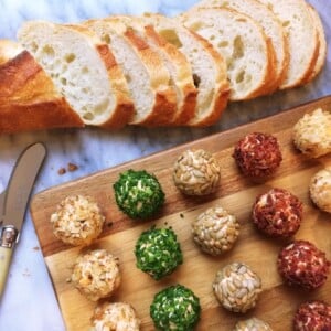 verschiedene Frischkäsebällchen mit Brot auf Schneidebrett serviert