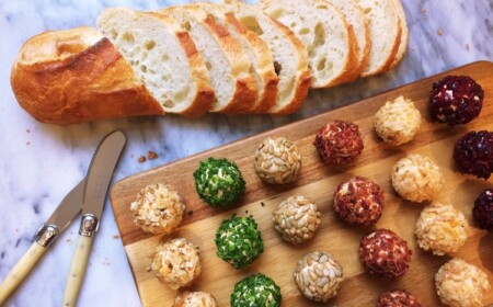 verschiedene Frischkäsebällchen mit Brot auf Schneidebrett serviert