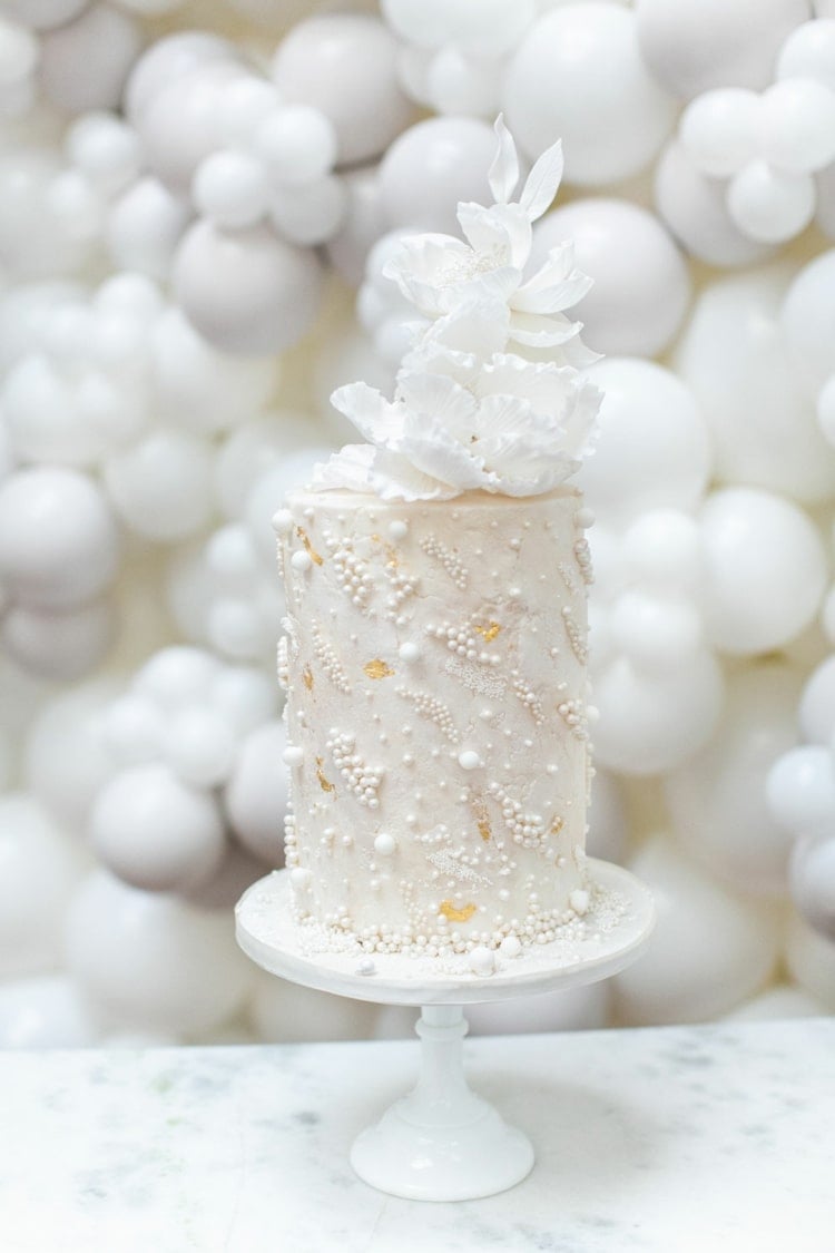 Einstöckige, zylinderförmige Torte in Weiß mit Perlen verziert