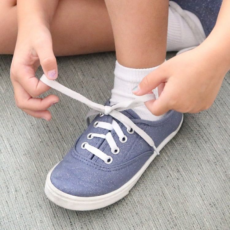 Entwicklung der Kinder fördern und das Schnüren von Schuhen beibringen