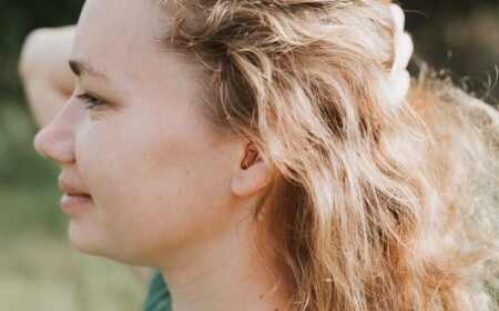 Frau mit im-Ohr-Hörgerät Tipps zum besser hören