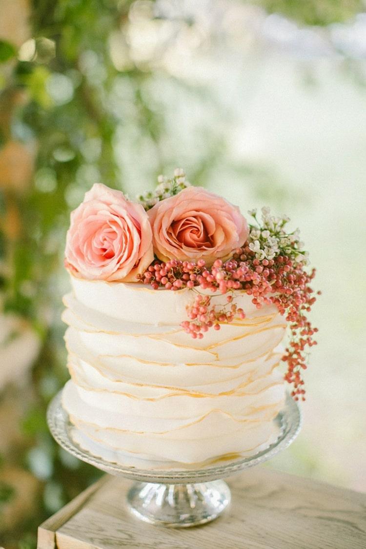 Geriffelte Hochzeitstorte mit rosa Blüten und Beeren verziert für einfache kleine Hochzeitstorten einstöckig