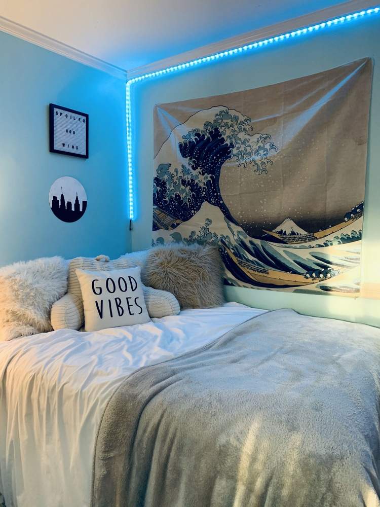 Jugendzimmer Deko mit blauer LED Lichtstreifen und Wandteppich mit Wellenmotiv
